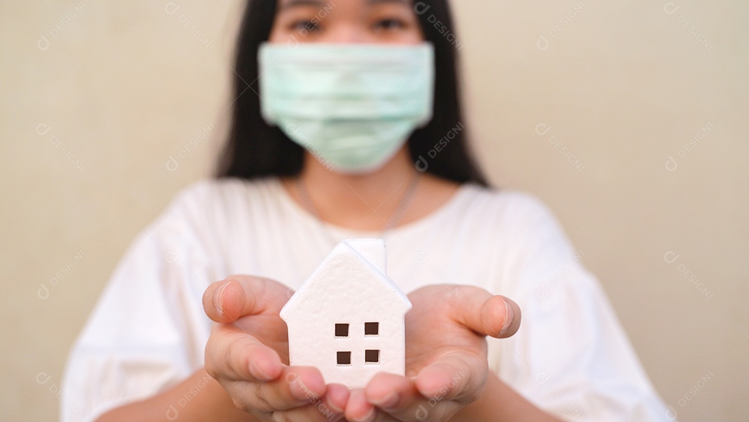 Mulher jovem asiática da geração do milênio segurando o modelo da casa branca