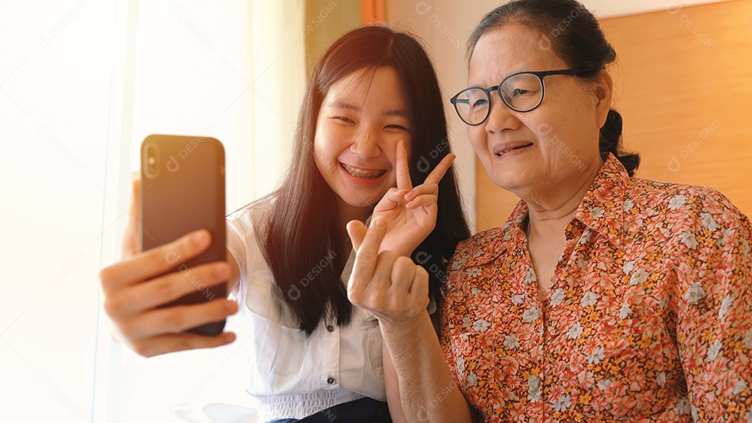 Avó asiática feliz e sua sobrinha se divertindo com o uso inteligente