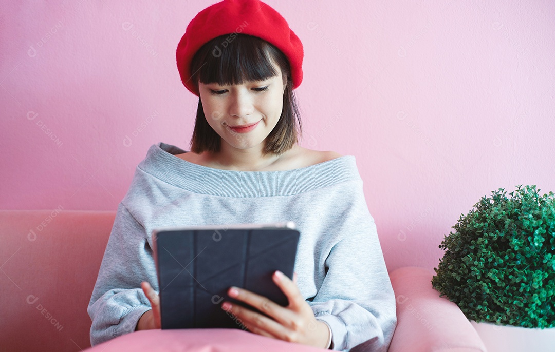 Jovem mulher milenar asiática feliz usando tablet digital