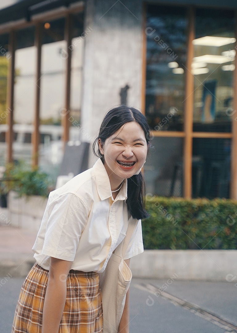 Feliz jovem asiática milenar sorrindo com aparelho no casual