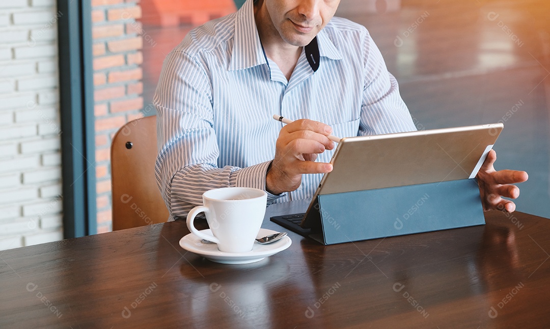 Empresário adulto trabalhando remotamente com tablet digital e bebida