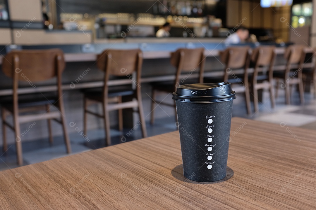 Tire a xícara de café na mesa de madeira em um café ou restaurante moderno