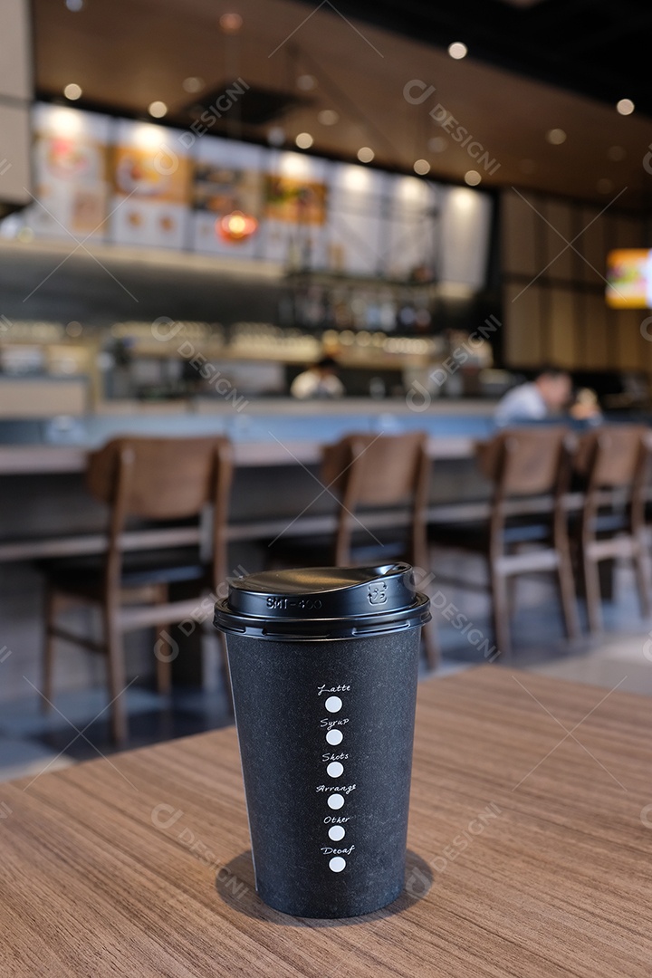 Tire a xícara de café na mesa de madeira em um café ou restaurante moderno