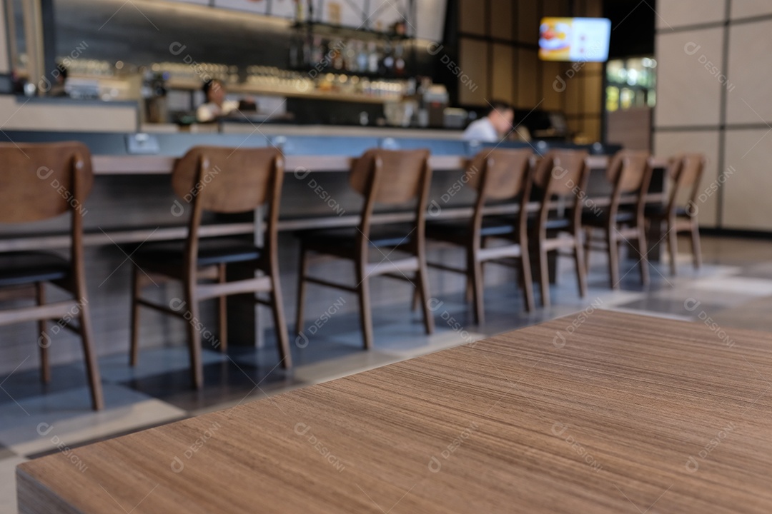 Mesa vazia de tábua de madeira em frente a um café ou restaurante desfocado