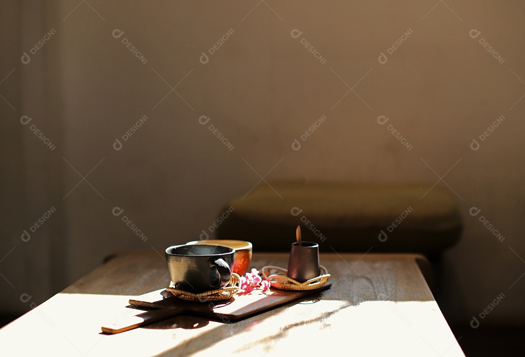 Caneca de café quente na mesa de madeira pela manhã com luz solar