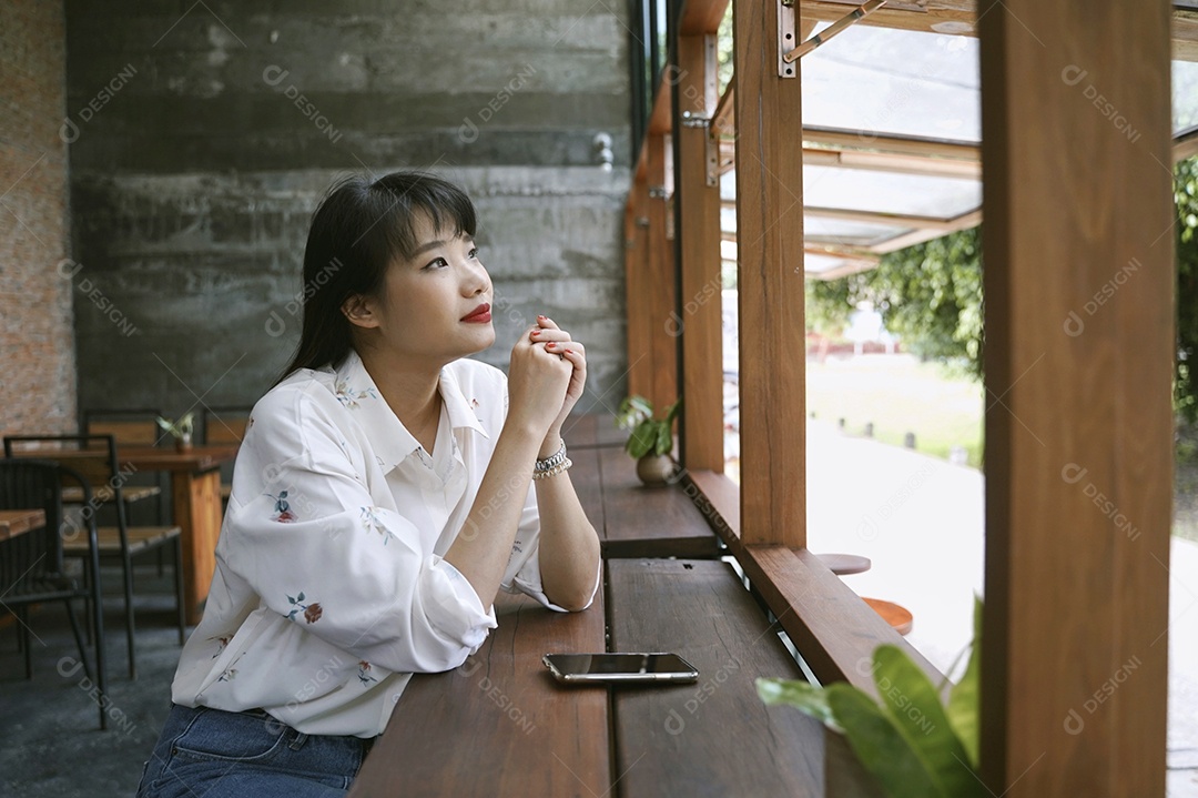 Jovem mulher atraente asiática em roupa casual pensando e relaxando