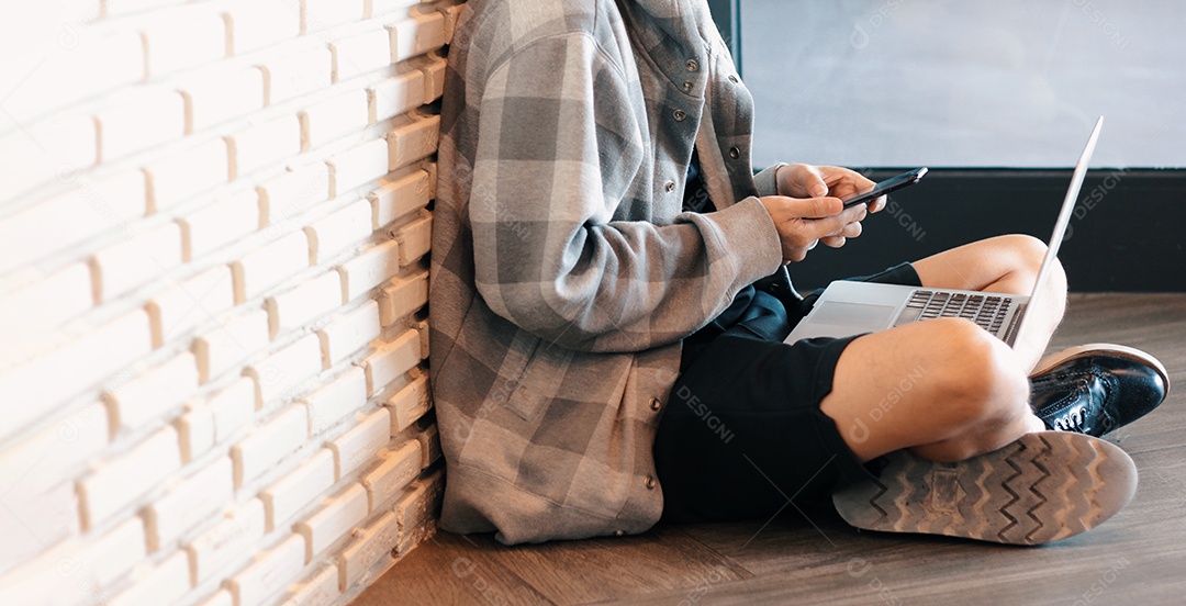 Jovem milenar sentado no chão e aprendendo aula online