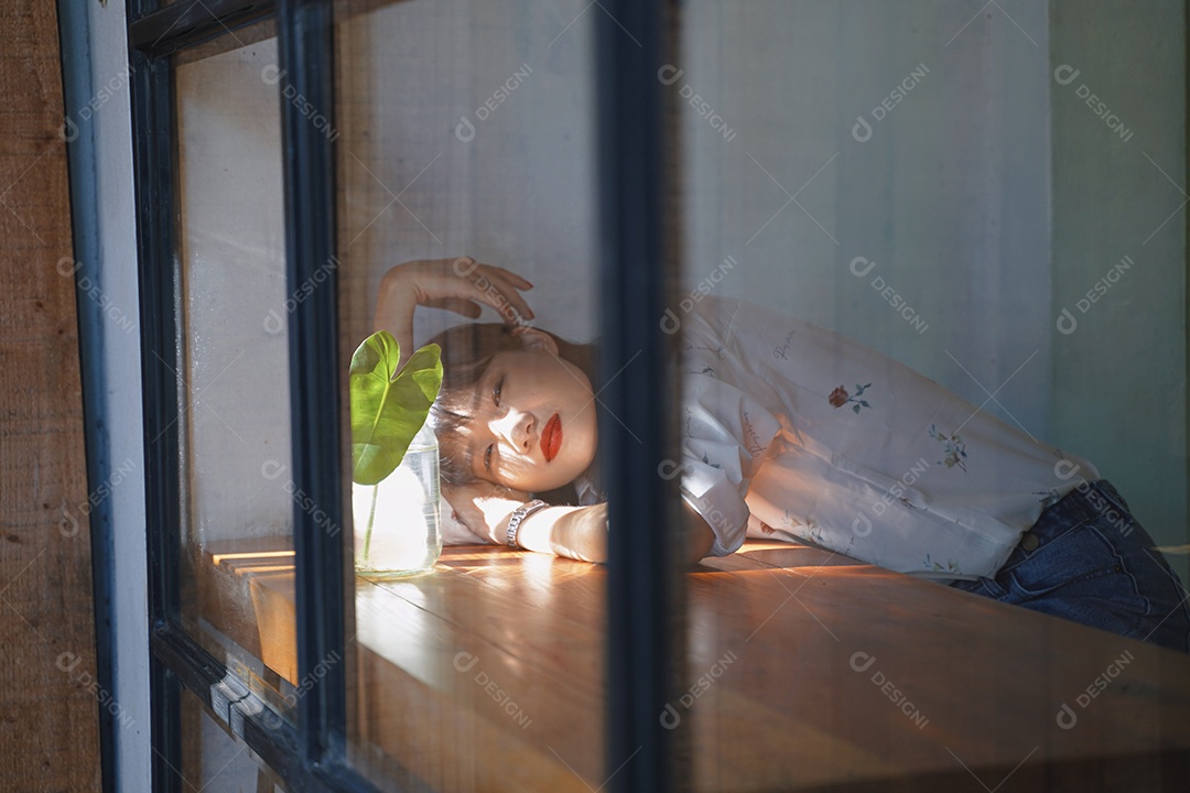 Mulher asiática atraente deitada na mesa