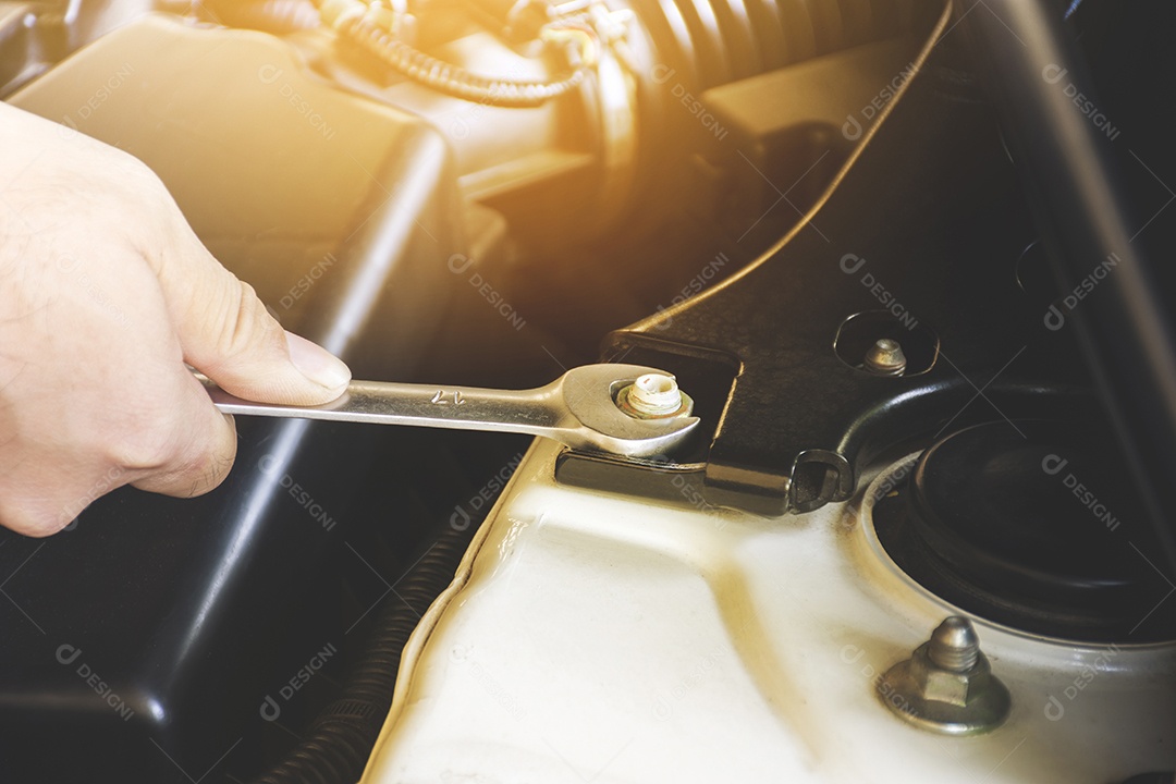 A mão do mecânico arrumando um automóvel