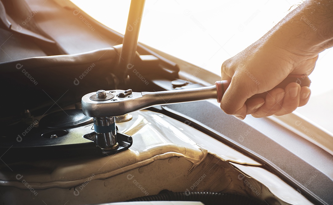 A mão do mecânico arrumando um automóvel