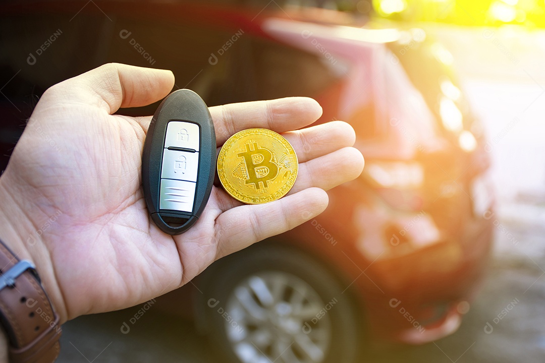 Criptomoeda bitcoin dourada e controle remoto sem chave do carro segurando