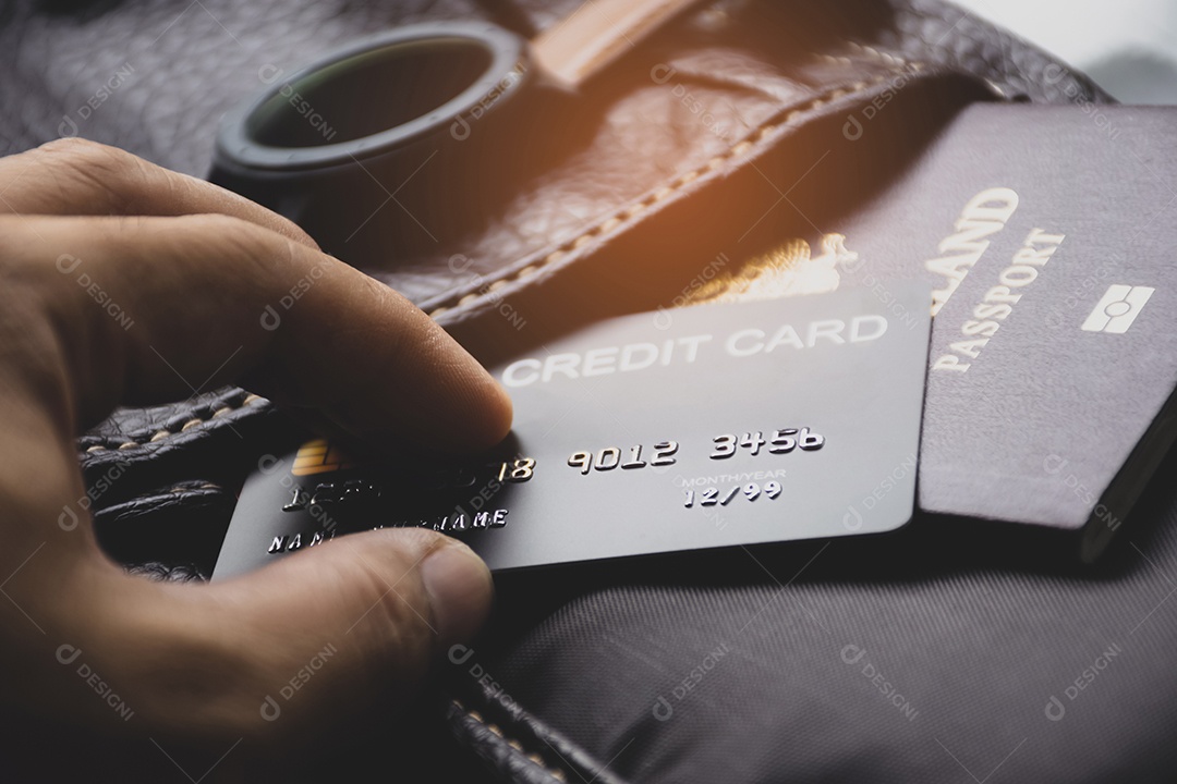 Mão de turista tirando cartão de crédito da carteira de couro com passaporte