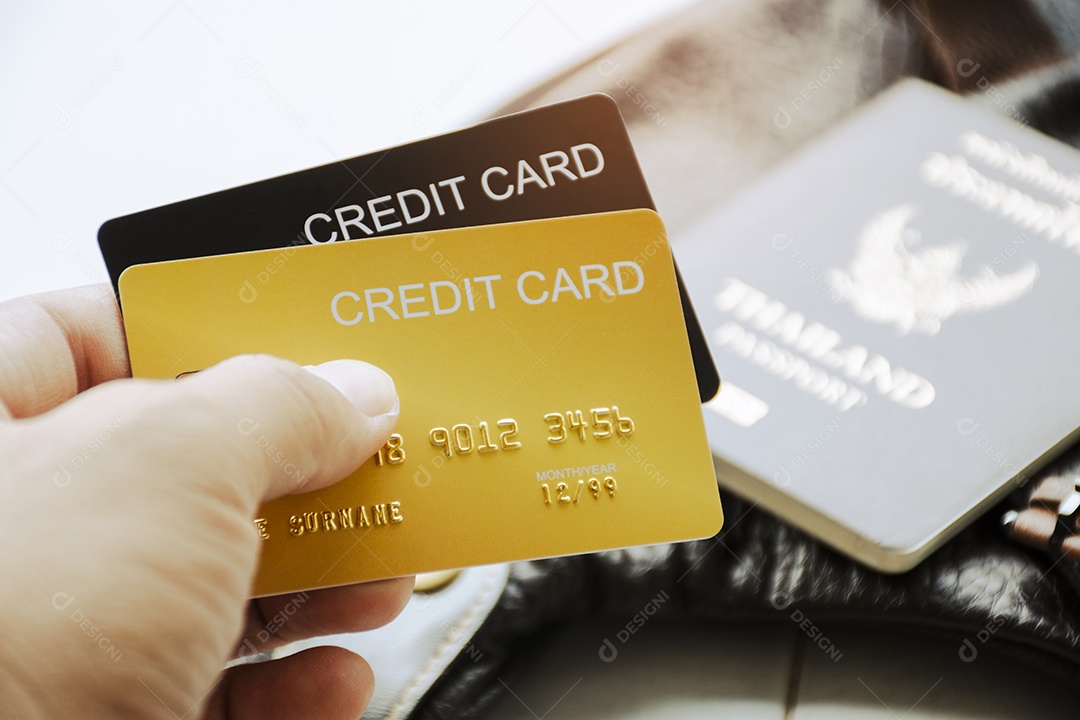 Cartão de crédito na mão do turista com fundo desfocado do passaporte
