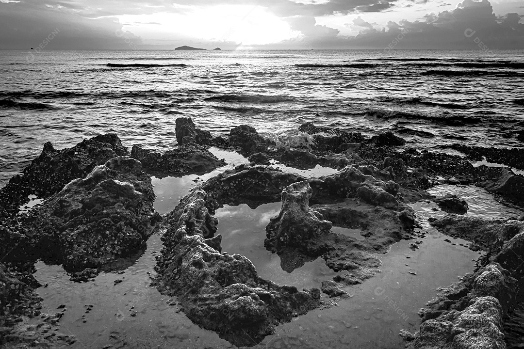 paisagem por do sol nas rochas da praia em primeiro plano