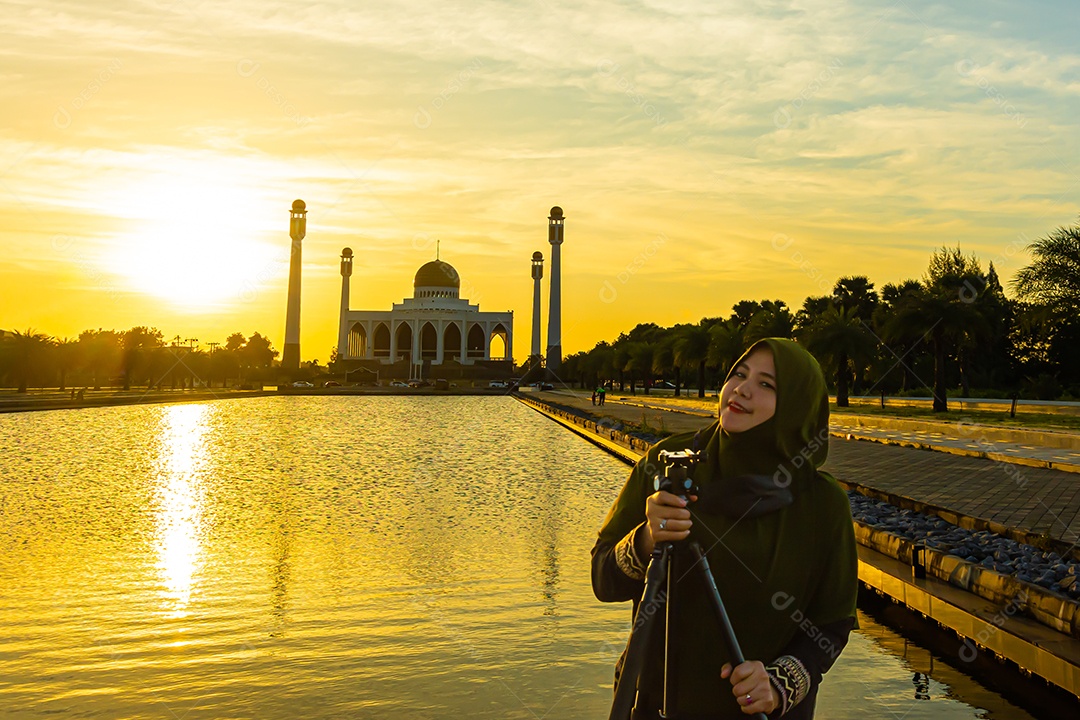Mesquita Central Songkhla de dia para noite com céus coloridos ao pôr do sol e as luzes da mesquita e reflexos na água no conceito de paisagem de referência