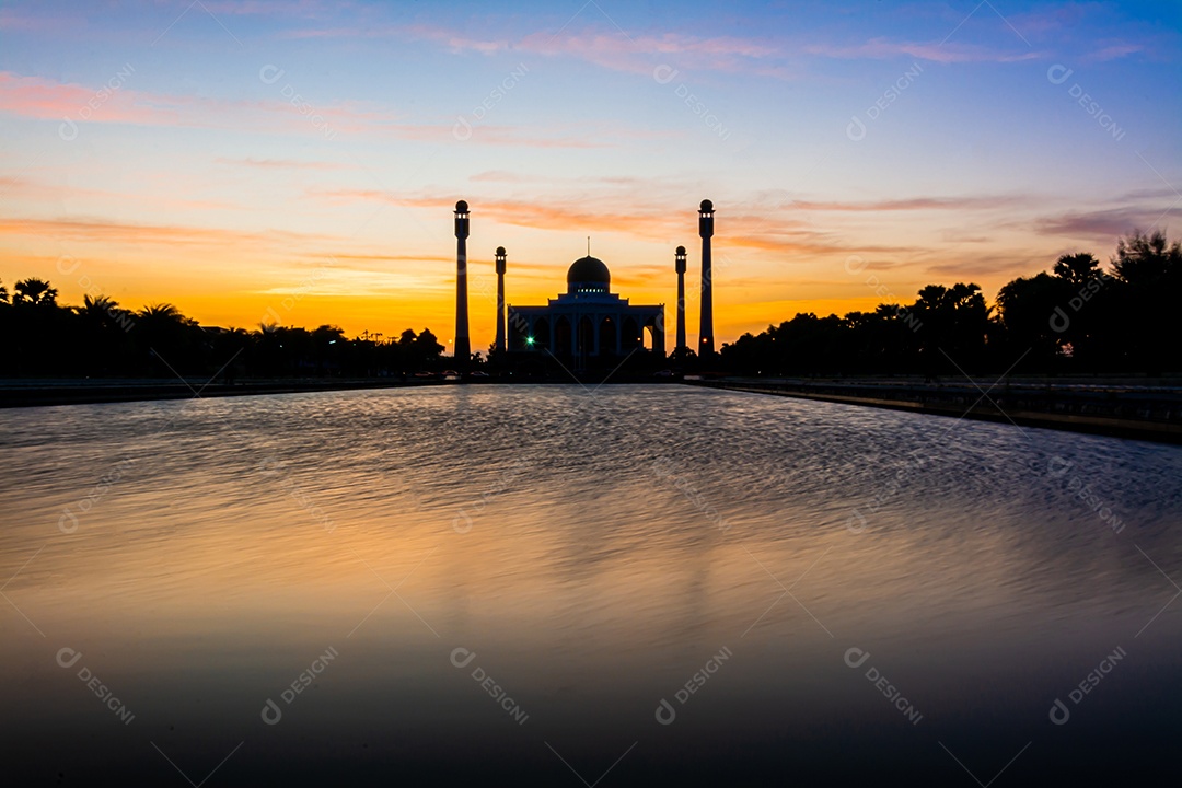 Mesquita Central Songkhla de dia para noite com céus coloridos ao pôr do sol e as luzes da mesquita e reflexos na água no conceito de paisagem de referência