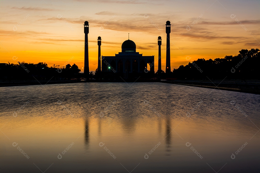 Mesquita Central Songkhla de dia para noite com céus coloridos ao pôr do sol e as luzes da mesquita e reflexos na água no conceito de paisagem de referência
