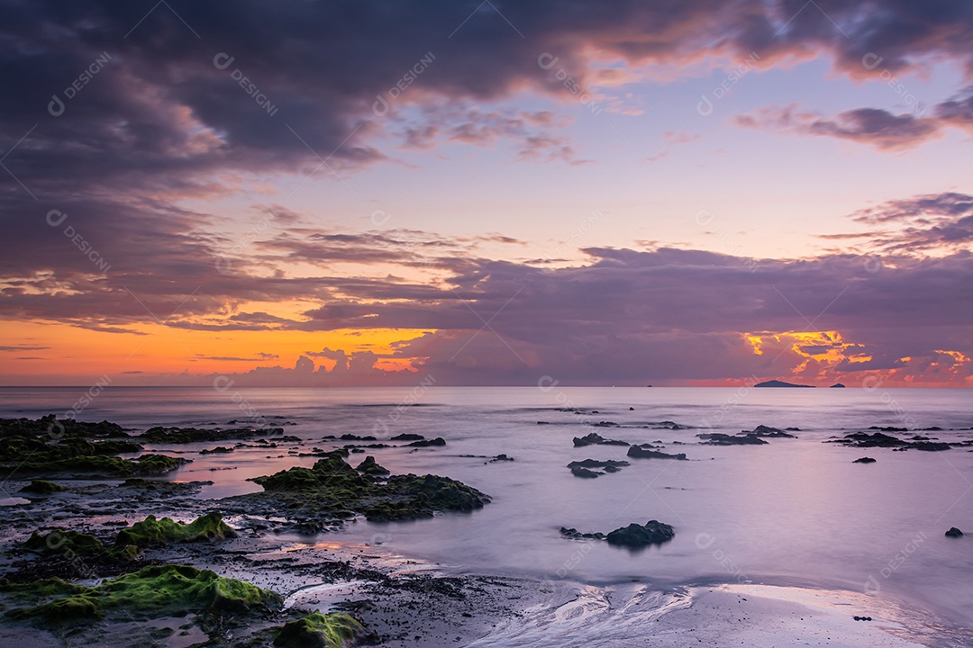 paisagem por do sol nas rochas da praia em primeiro plano
