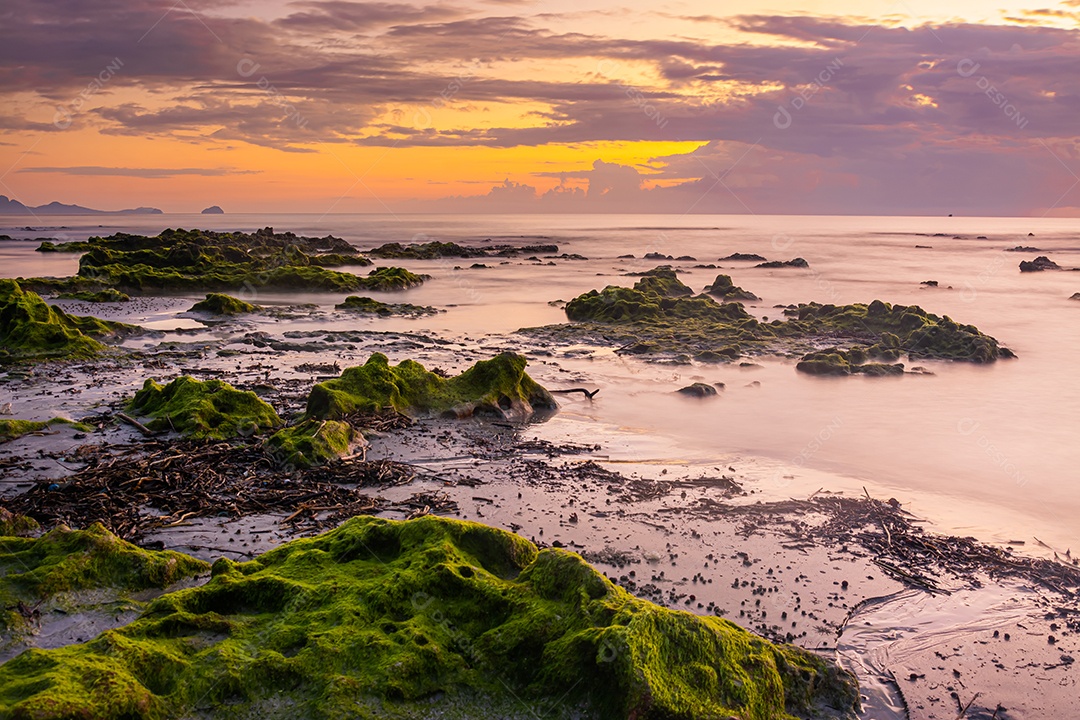 paisagem por do sol nas rochas da praia em primeiro plano