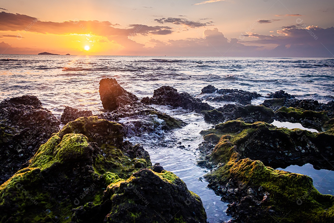 paisagem por do sol nas rochas da praia em primeiro plano
