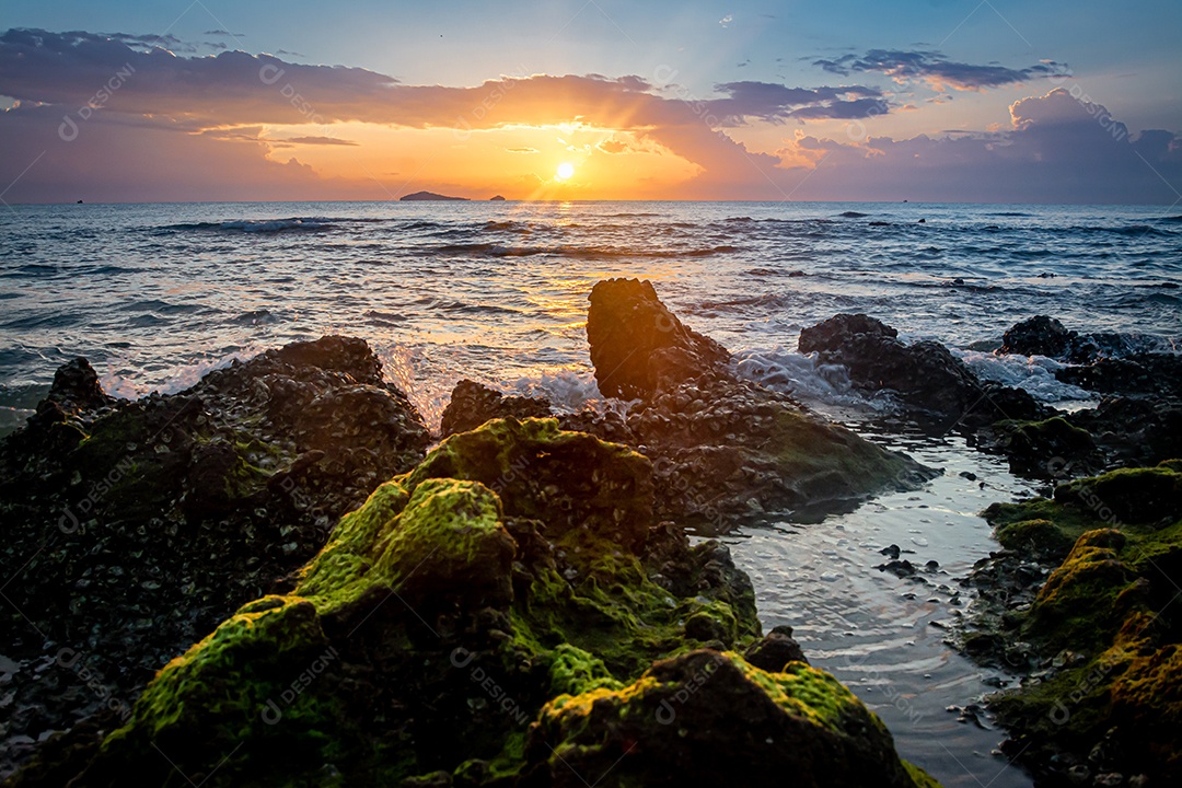 paisagem por do sol nas rochas da praia em primeiro plano