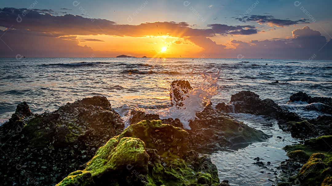 paisagem por do sol nas rochas da praia em primeiro plano