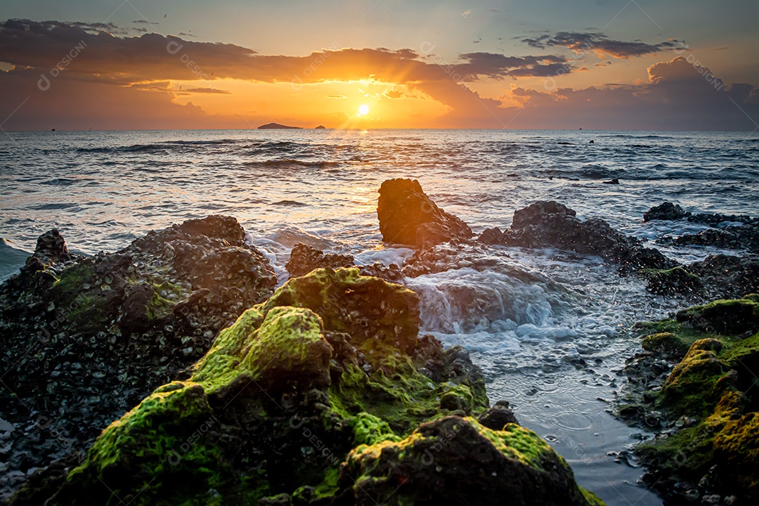 paisagem por do sol nas rochas da praia em primeiro plano