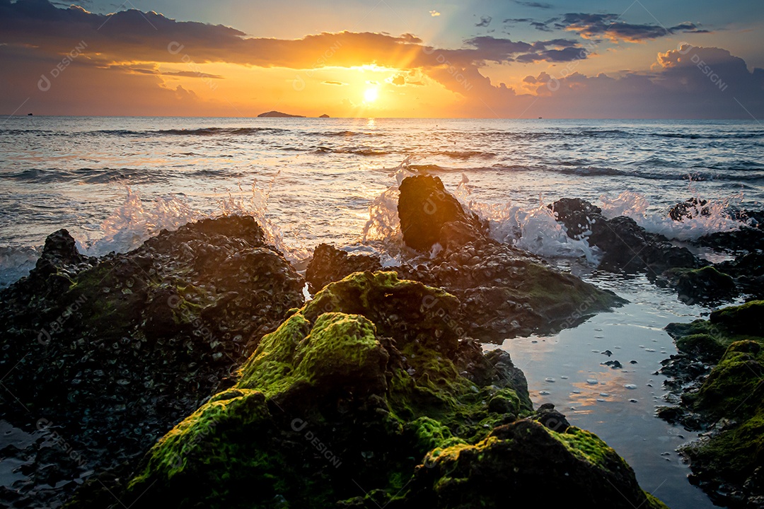 paisagem por do sol nas rochas da praia em primeiro plano