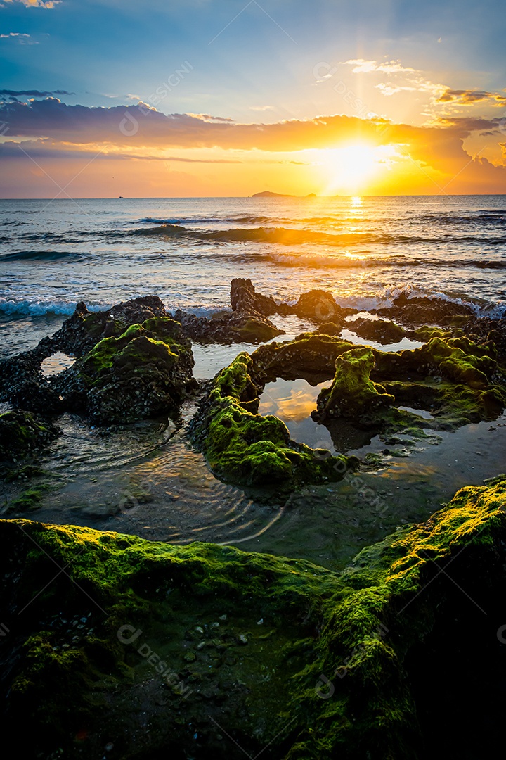 paisagem por do sol nas rochas da praia em primeiro plano