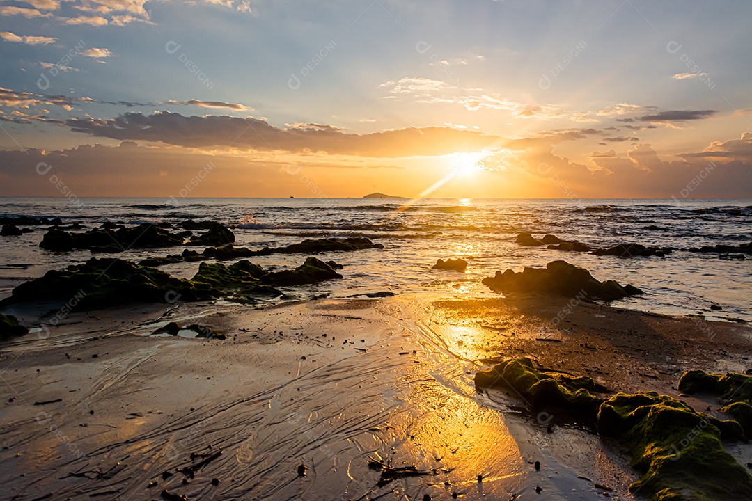 paisagem por do sol nas rochas da praia em primeiro plano