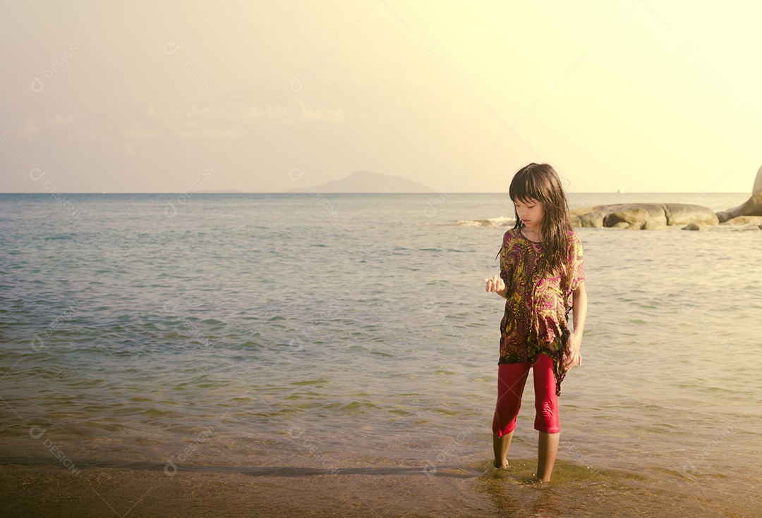 Criança andando na praia