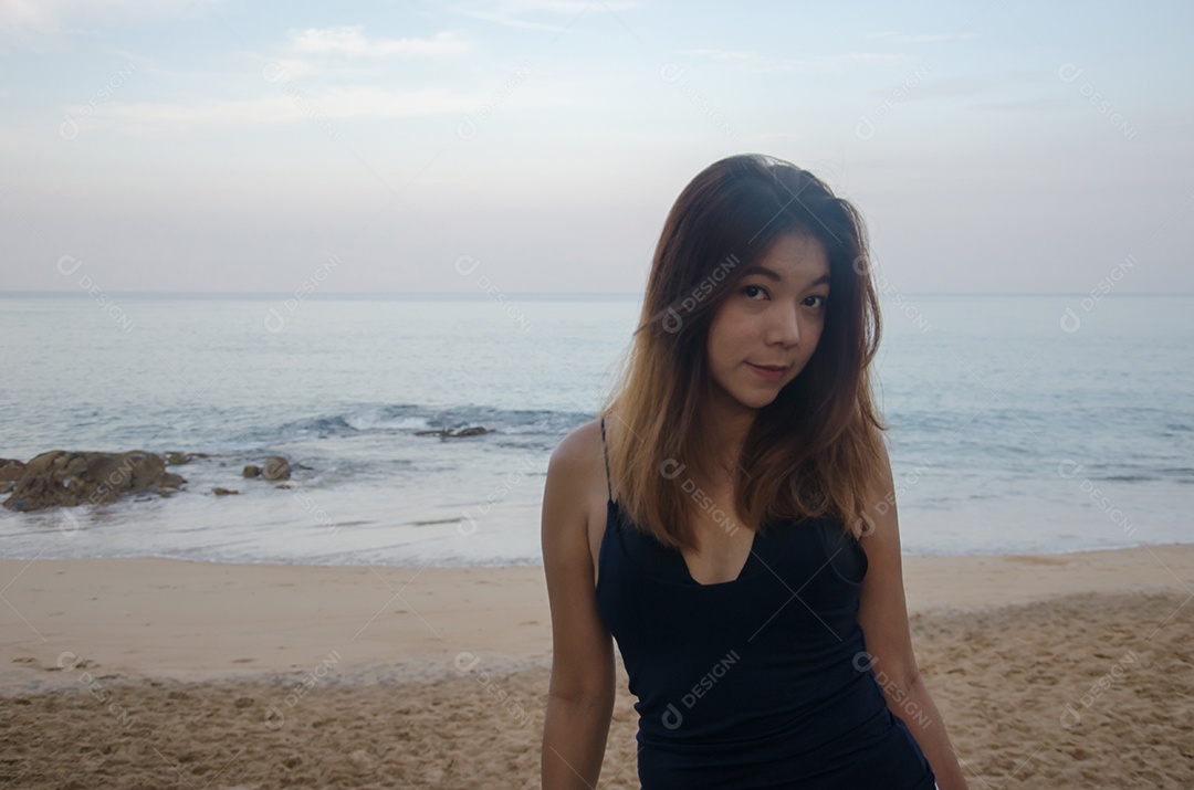 Mulheres asiáticas sensuais no pôr do sol da praia