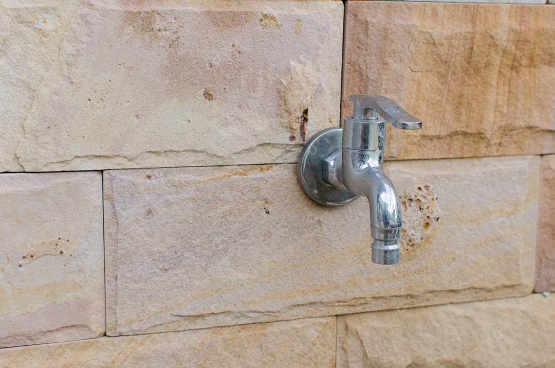 Torneira na parede de tijolos bonita