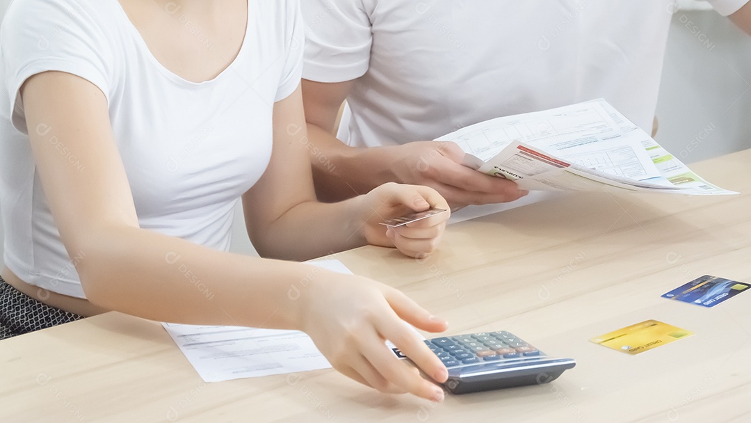 Homem e mulher estão endividados com faturas de cartões de crédito.
