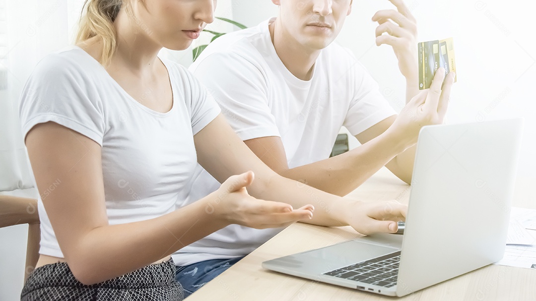 Homem e mulher estão endividados com faturas de cartões de crédito.