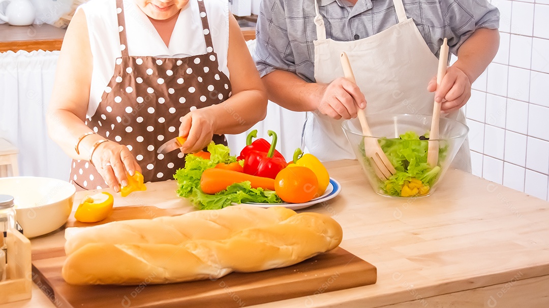 Casal de idosos está ajudando a cozinhar na cozinha.