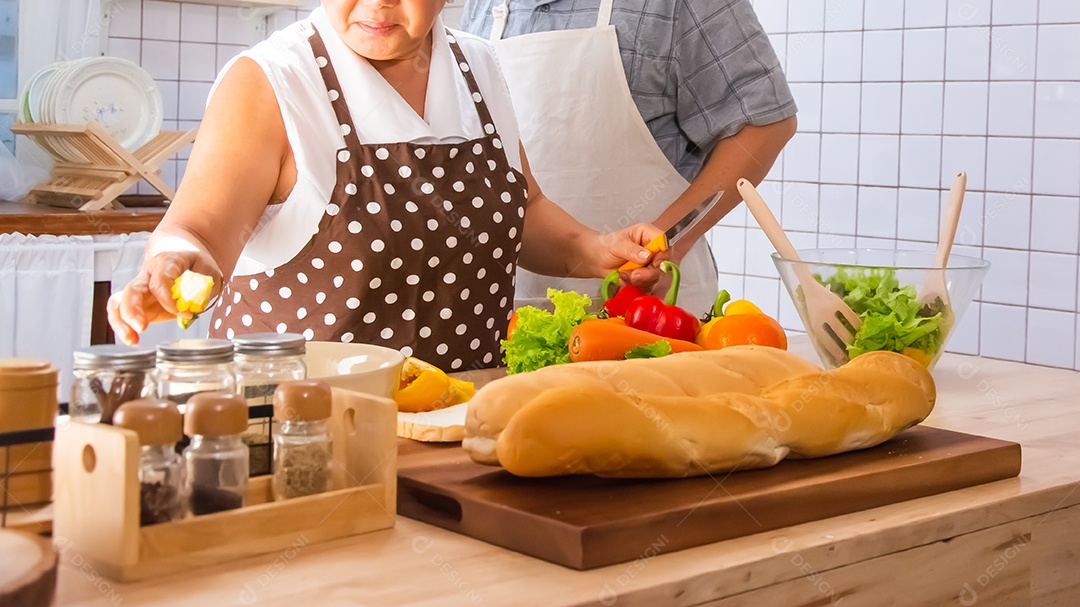 Casal de idosos está ajudando a cozinhar na cozinha.
