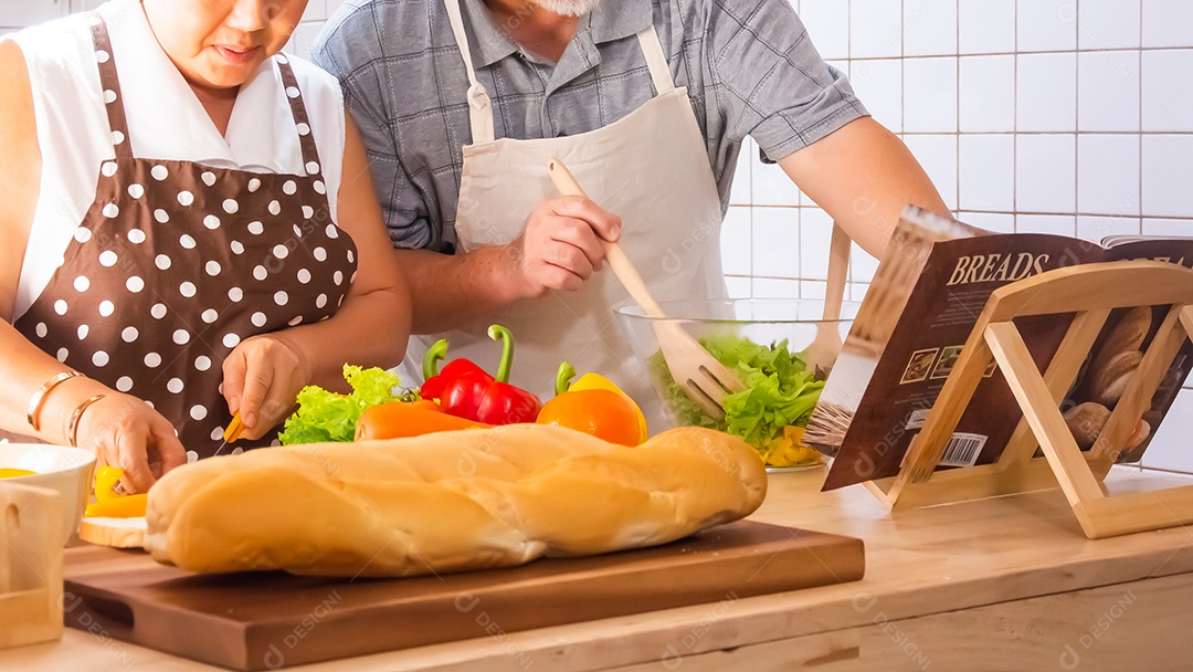 Casal de idosos está ajudando a cozinhar na cozinha.
