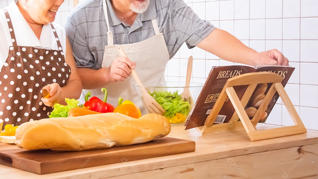 Casal de idosos está ajudando a cozinhar na cozinha.