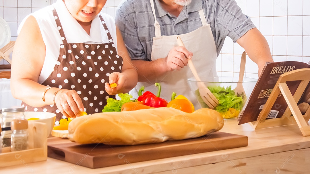 Casal de idosos está ajudando a cozinhar na cozinha.