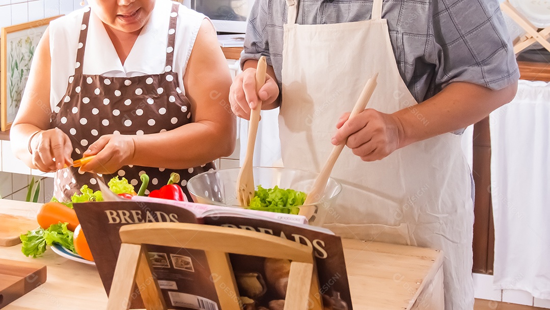 Casal de idosos está ajudando a cozinhar na cozinha.