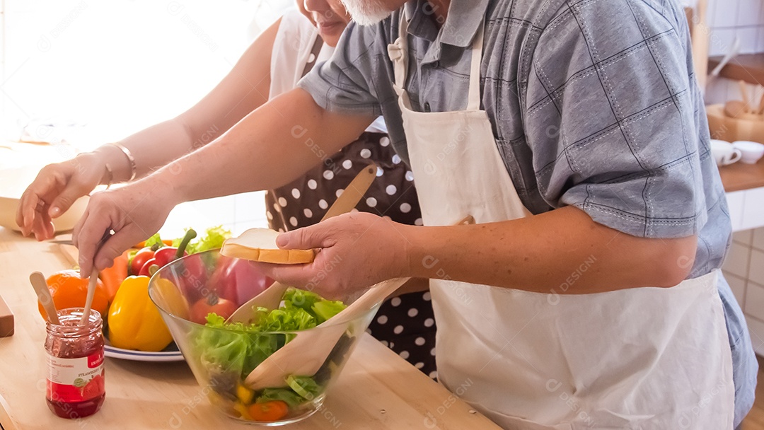 Casal de idosos está ajudando a cozinhar na cozinha.