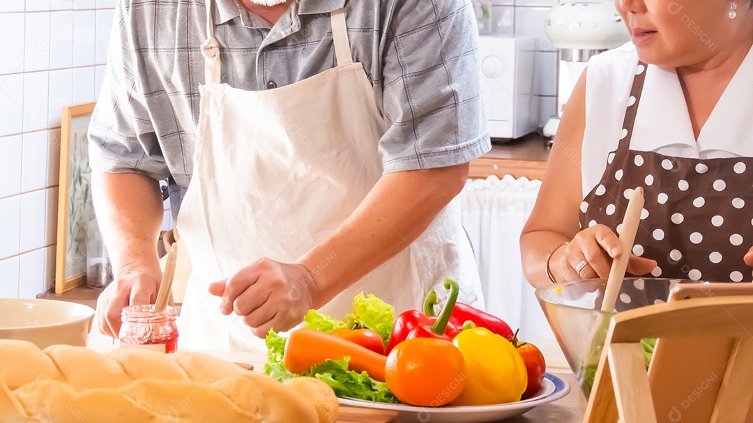 Casal de idosos está ajudando a cozinhar na cozinha.