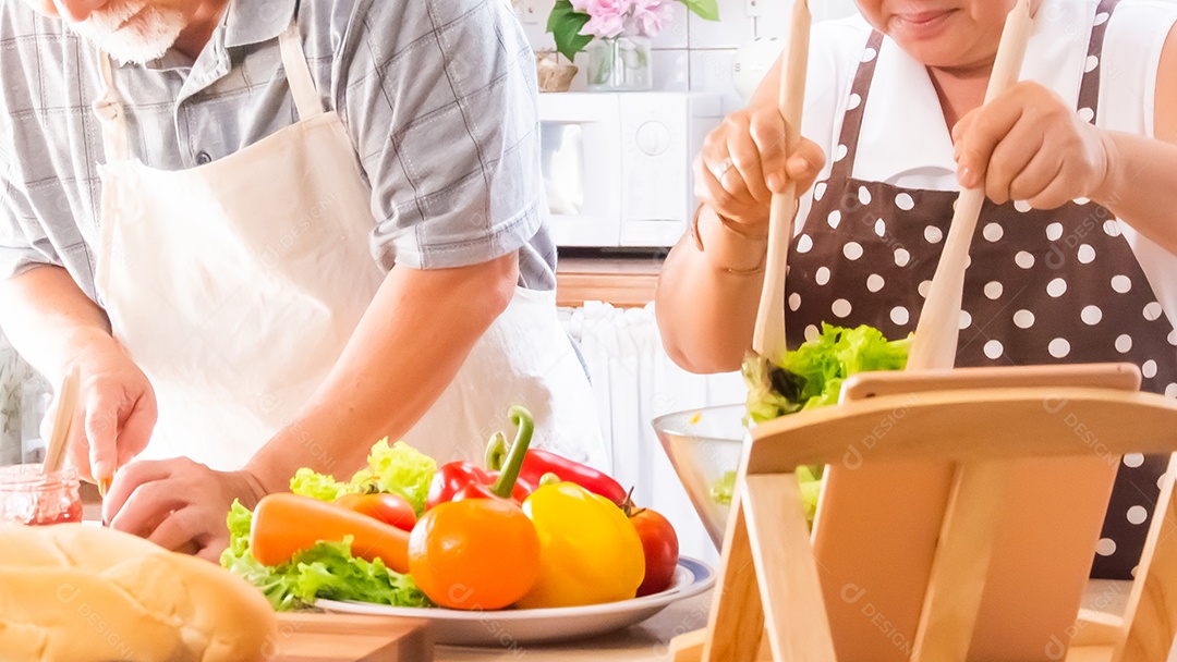 Casal de idosos está ajudando a cozinhar na cozinha.