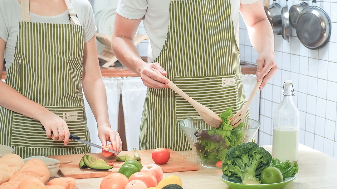 Casal de idosos está ajudando a cozinhar na cozinha.