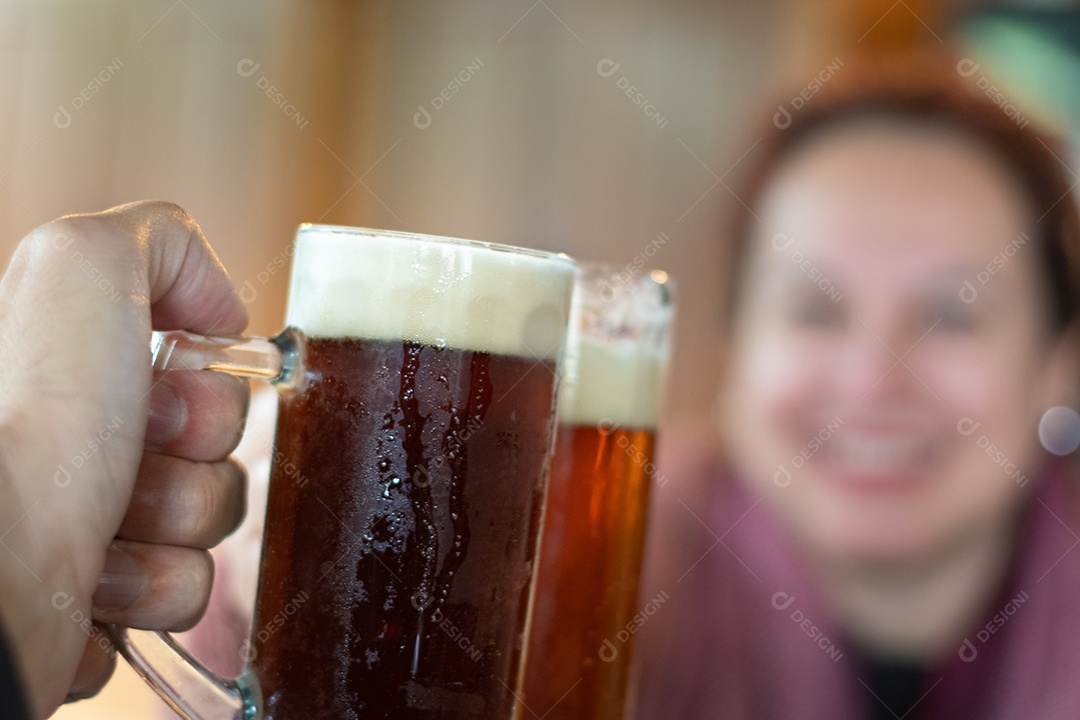Duas pessoas brindando com de cerveja