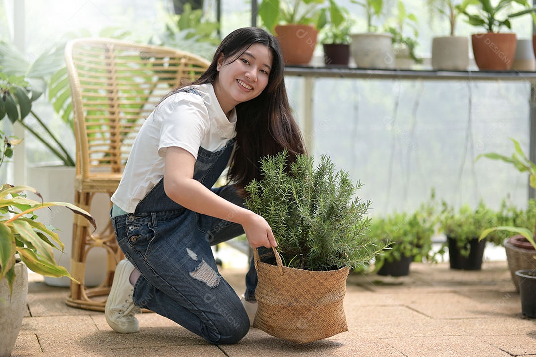 Jovem mulher plantando e cuidando de árvores em estufas, plantando e cuidando de equipamentos, pequenas empresas.