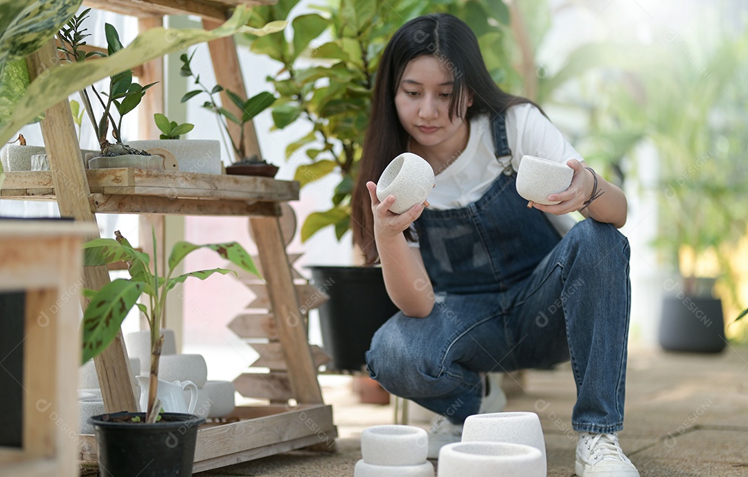 Jovem mulher plantando e cuidando de árvores em estufas, plantando e cuidando de equipamentos, pequenas empresas.
