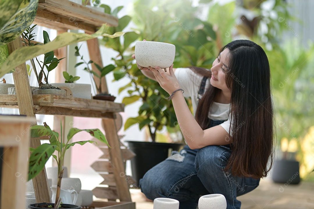 Jovem mulher plantando e cuidando de árvores em estufas, plantando e cuidando de equipamentos, pequenas empresas.