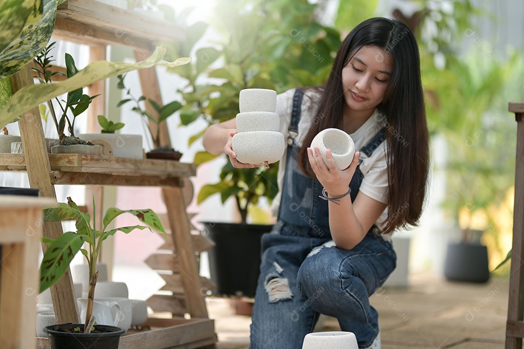 Jovem mulher plantando e cuidando de árvores em estufas, plantando e cuidando de equipamentos, pequenas empresas.